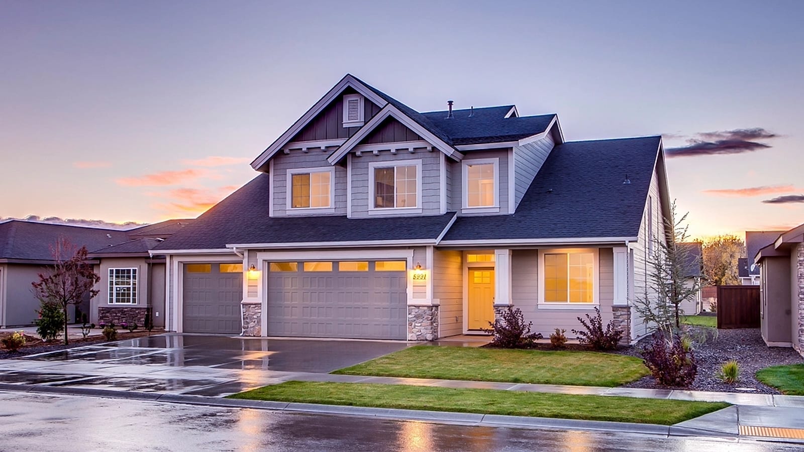 A two-story home at golden hour with its roofline and gutter runs in warm evening light &mdash; representative imagery